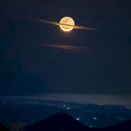 A bright full moon sits above dark mountains over a night sea, with glowing streaks across the sky.