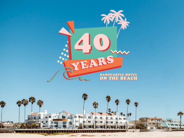 A beach scene with palm trees and a &ldquo;40 Years&rdquo; logo reading &ldquo;Sandcastle Hotel on the Beach.&rdquo;
